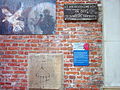 Tafeln am Portal: U. a. historische Grabplatte