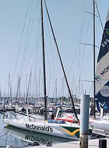 Vu de trois quarts avant, voilier blanc amarré au ponton.