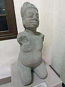 Estatua del siglo IX de un hombre gordo arrodillado con mukuta y mostacho.