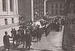 Fridtjof Nansens kiste lå på paradeseng foran søylehallen i Midtbygget før begravelsen 17. mai 1930. Bildet viser båren som føres fra Universitetsplassen.