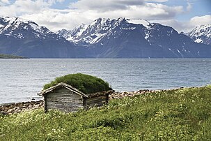 Cabane à toit de gazon au bord du fjord de Lyngen et face aux Alpes de Lyngen, dans le Nord de la Norvège. (définition réelle 3 300 × 2 200)