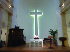 Intérieur du temple, chaire, table, bible, baptistère et croix.