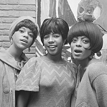 Black-and-white image of the Supremes smiling.