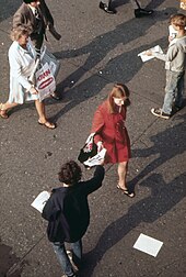 Leaflets being handed out in New York City (1973) Without breaking stride, homeward bound commuter as the Staten Island Ferry Terminal reaches for leaflet from street... - NARA - 549907.jpg
