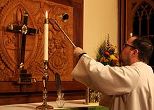 An Episcopal acolyte lighting an altar candle AltarCandleLight.jpg
