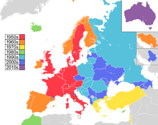 Mapa de países da Europa, Norte da África e Ásia Ocidental, com a Austrália como inserção no canto superior direito, colorido para indicar a década em que eles participaram pela primeira vez do concurso: 1950 em vermelho, 1960 em laranja, 1970 em amarelo, 1980s em verde; Década de 1990 em azul celeste; 2000s em azul; e 2010 em roxo