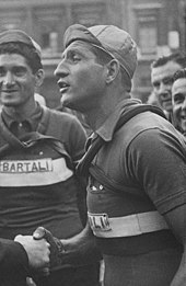 Photographie en noir et blanc d'un cycliste portant une casquette.