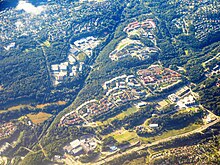 Luftbild von mehreren mit Waldflächen umgebenen Siedlungen