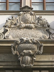 Erb a jméno hraběnky Johany Františky Magnisové, fundátorky brněnského Paláce šlechtičen v horní části kartuše na portálu budovy. Dole je knížecí erb kardinála Ditrichštejna.