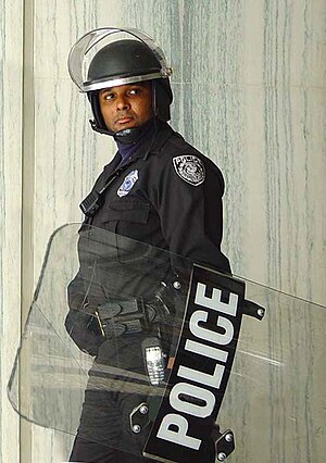 Police officer with a riot shield.