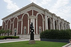 Exterior cornice of the Meadows Museum, with a black sculpture in front.