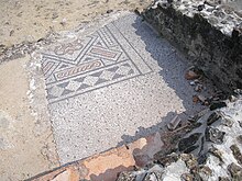 Mosaïque antique au sol, partiellement détruite au passage d'une rue.