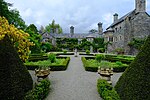 a path through a knot garden with the manor house behind it