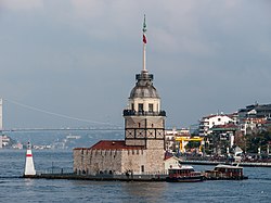 A tower on a small island, with a ship nearby