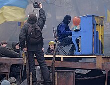 Protester performs on the roof of burned "Berkut" bus. The barricade across Hrushevskoho str. Kyiv, 10 February 2014. Protester Piano Extremist plays on the roof burned "Berkut" bus. The barricade across Hrushevskoho str. Kiev, 10.02.2014..jpg
