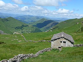 Cabaña pasiega en el puerto de las Estacas de Trueba con el valle del Pas al fondo.jpg