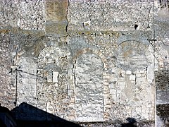 Photographie en couleurs d'un mur dont les baies ont été murées.