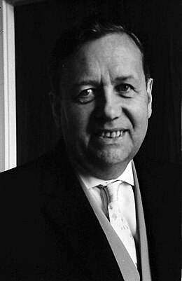 Photo en noir et blanc. Visage d'un homme portant un veston.