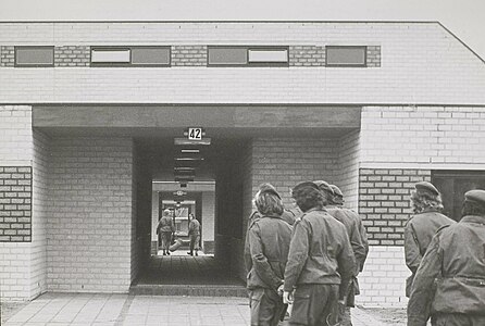 (halverwege jaren 70) Dienstplichtigen lopen onder de legeringsgebouwen door.