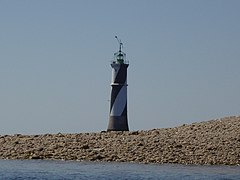 Vue d’un phare en arrière-plan d’une plage, le corps blanc et noir.