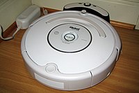 Roomba vacuum cleaner docked in base station Roomba3g.jpg
