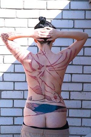 English: woman´s back with tattoos Deutsch: ju...