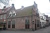 Hoek Lieve Vrouwe Kerkhof. Z.g. "Kapellehuis". Trapgevel met zandstenen en gemetseld kozijn en overhoekse pinakels. Blinde vensternissen met metselwerk versierd. Zetel van de kapelmeesters der Onze Lieve Vrouwekapel