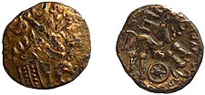 Pokovený zlatý statér z jižní oblasti kmene Atrebatů, vyražený pro Commia a datovaný do období cca 50-25 př. n. l., „Commius E-Type“. Na lícové straně je design věnce. Na rubové straně je kůň, dole kolo a vlevo symbol E s nápisem [CO]MMIOS.