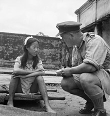 A liberated Chinese girl who had been forced in to sexual slavery by the Japanese military sits on a stretcher and speaks to a British military serviceman. Chinese girl from one of the Japanese Army's 'comfort battalions'.jpg
