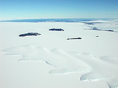 Die Erebus-Gletscherzunge in der zugefrorenen Erebus Bay mit den Dellbridge-Inseln (Mitte) und Kap Evans (rechts oben)