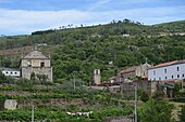 Photographie de collines dans lesquelles s'insère un bâtiment monastique.