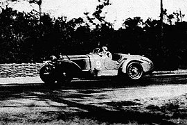 Photo d'une homme pilotant une voiture en course.