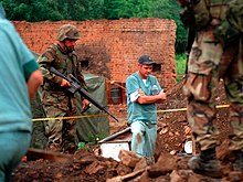 Marines from the U.S. provide security for Canadian policemen as they investigate a mass grave in July 1999. RCMP in Kosovo.jpg