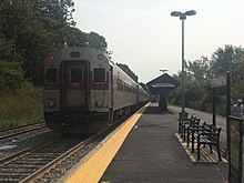 A commuter rail train at a low-platform station