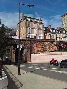 Vue d'une rue et à l'arrière-plan vestiges d'un mur et bâtiments récents