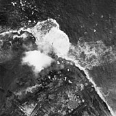 Aerial photograph of bombs exploding on dike on 3 October 1944