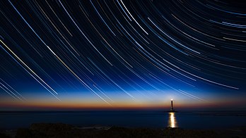 Trilhas de estrelas circumpolares em uma fotografia obtida pela exposição de 125 minutos tomada próximo ao farol do Cabo de la Hague, Normandia, França. (definição 5 944 × 3 344)