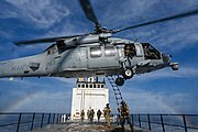 An MH-60S of HSM-85 picks up Navy SEALs from the deck of ATLS-9701 during an exercise, 2022