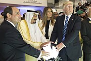 Trump, King Salman of Saudi Arabia, and Abdel Fattah el-Sisi place their hands on a glowing white orb light at waist level