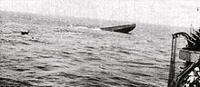 Photographie en noir et blanc de l'étrave d'un sous-marin en train de couler.
