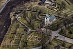 Modernare flygfoto över Reftele kyrka samt hela kyrkogården.