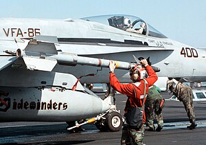 US Navy 980220-N-0507F-003 U.S. Marine Corps Lance Cpl. Leander Pickens arms an AIM-9 Sidewinder missile on a FA-18C Hornet.jpg