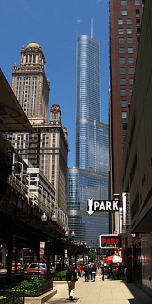 street view of elevated train tracks and with tall buildings in the background