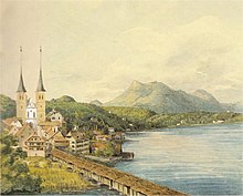 watercolour sketch of lakeside scene in springtime, water taking up right hand side of sketch, church and small town at left, hills in background