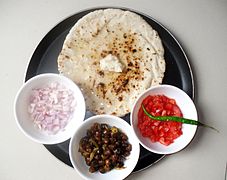 Chapati served with various sides and topped with butter.