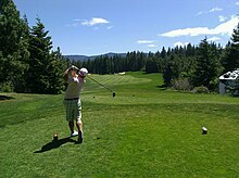 A golfer in the finishing position after hitting a tee shot Golfer swing.jpg