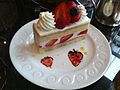 Un gâteau à étages avec des fraises dans le glaçage et la garniture