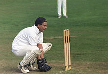 Wicket-keeper in characteristic full squatting position, facing a delivery from a slow pace or spin bowler Cricket wicket keeper.jpg