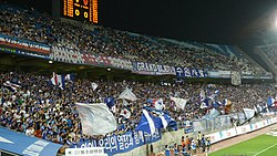 Трибуна, полная корейских фанатов, аплодирующих после гола.