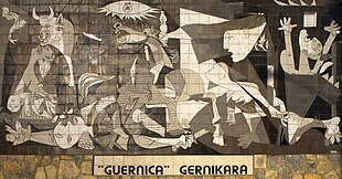 Mural in Guernica based on the Picasso painting. Basque nationalists advocate that the painting be brought to the town, as can be seen in the slogan underneath. Mural del Gernika.jpg